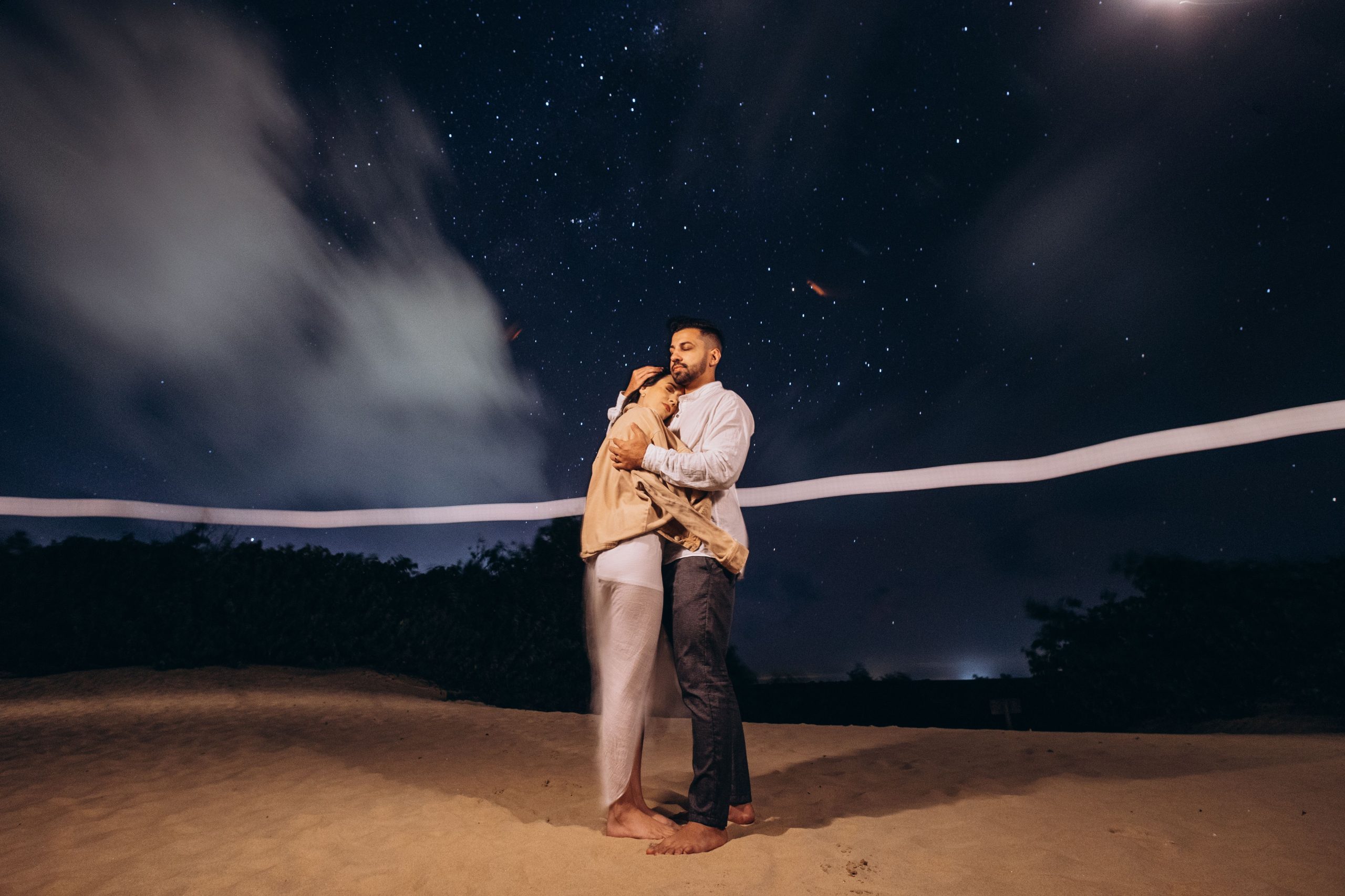 Couple sur plage sous ciel étoilé