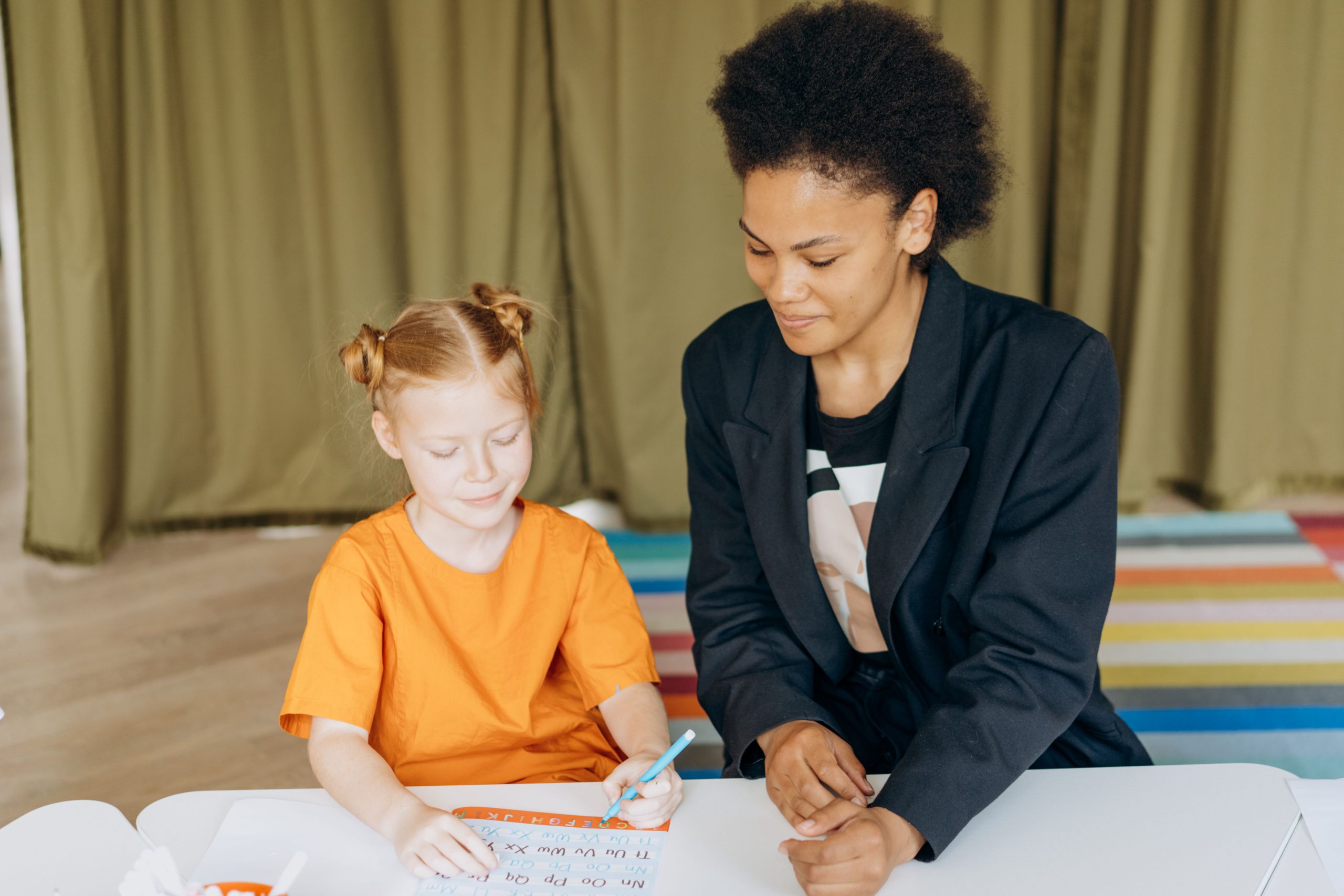 Enfant apprenant avec son enseignante attentive