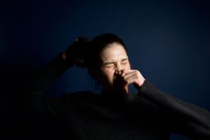 Femme éternuant sur fond bleu
