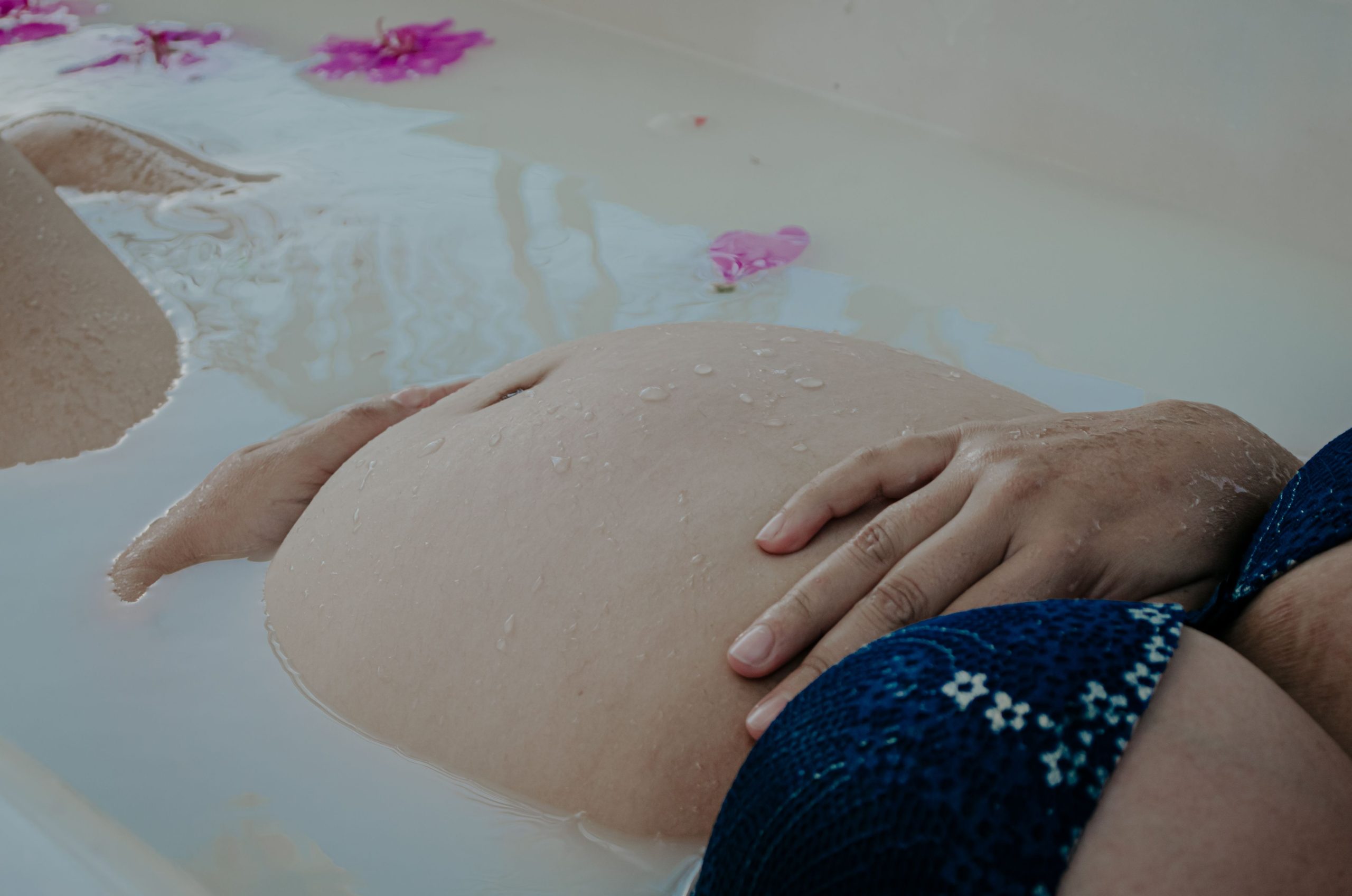 Femme enceinte relaxant dans bain lait fleuri
