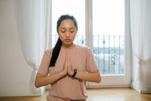 Femme asiatique méditant les mains jointes