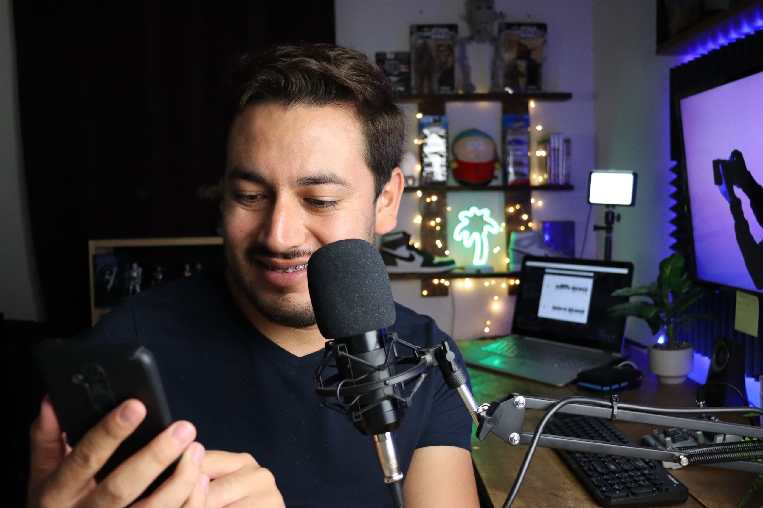 Homme assis au bureau avec microphone et smartphone