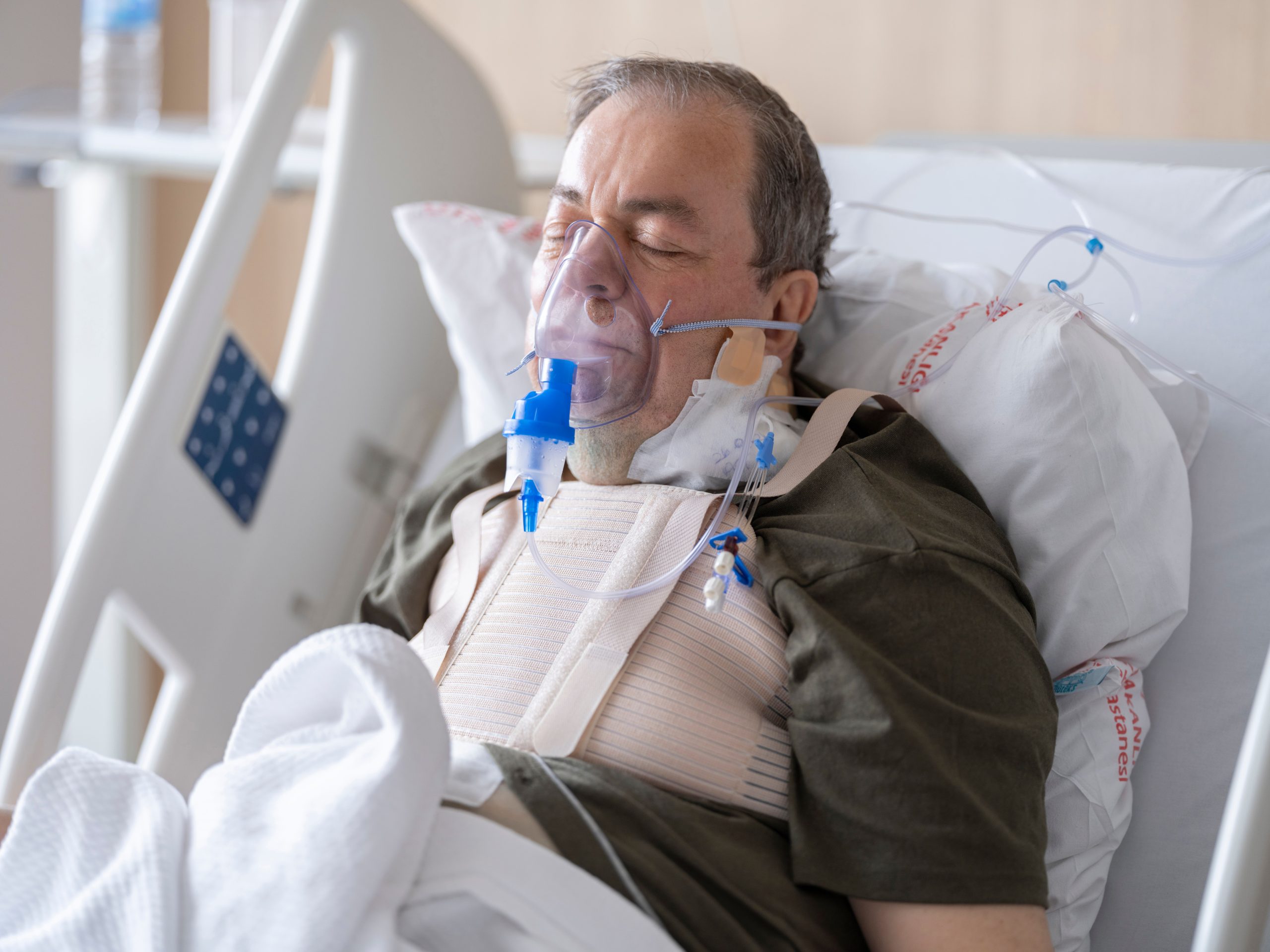 Homme âgé au lit d'hôpital avec masque oxygène