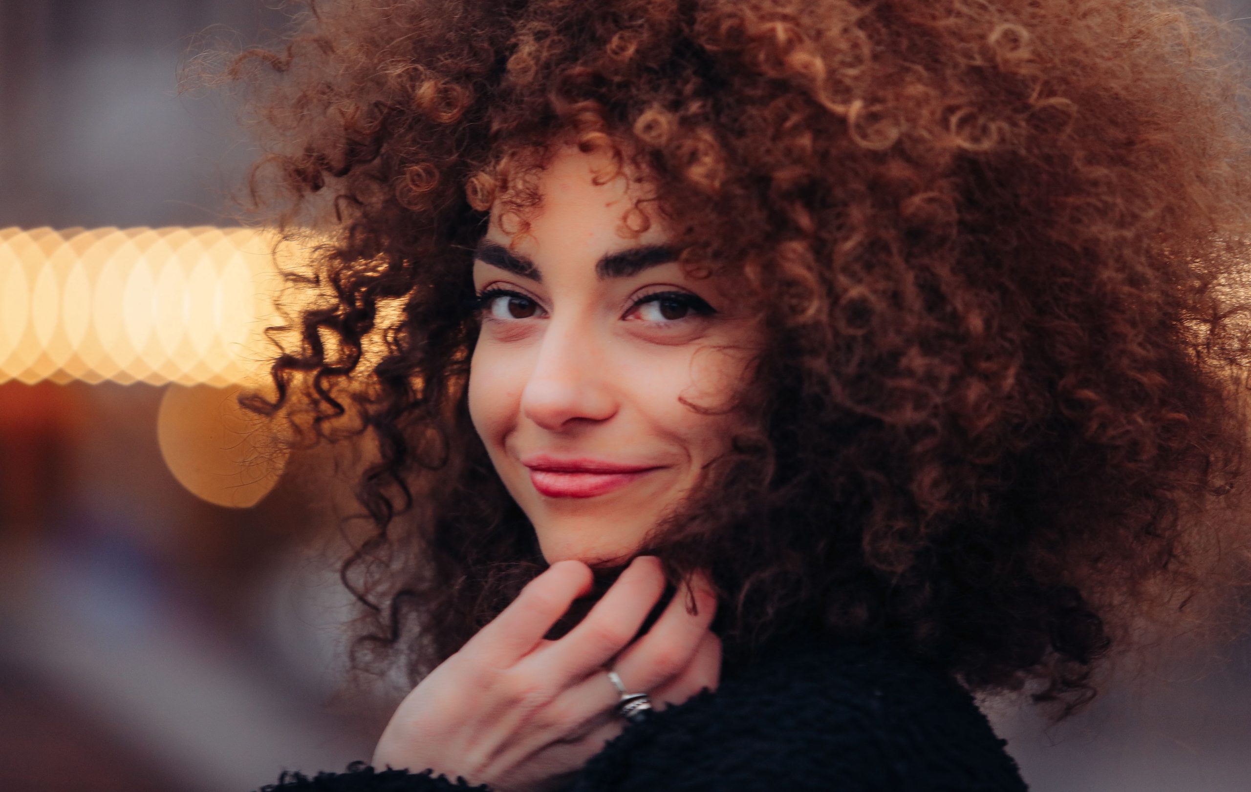 Portrait femme cheveux boucles sourire lumiere naturelle