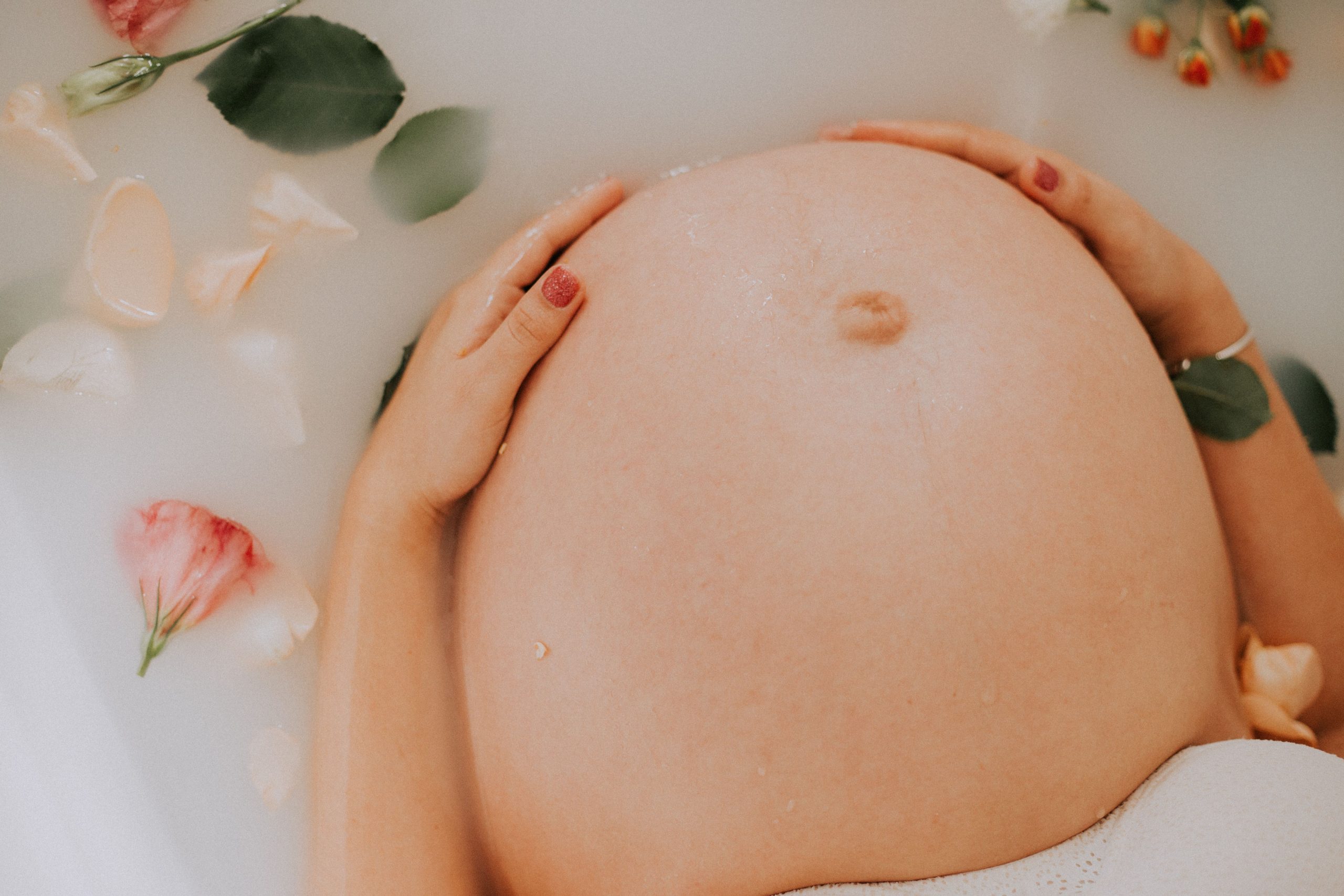 Femme enceinte détente bain lait fleurs maternité