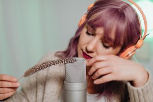 Femme enregistrant ASMR avec plume et microphone