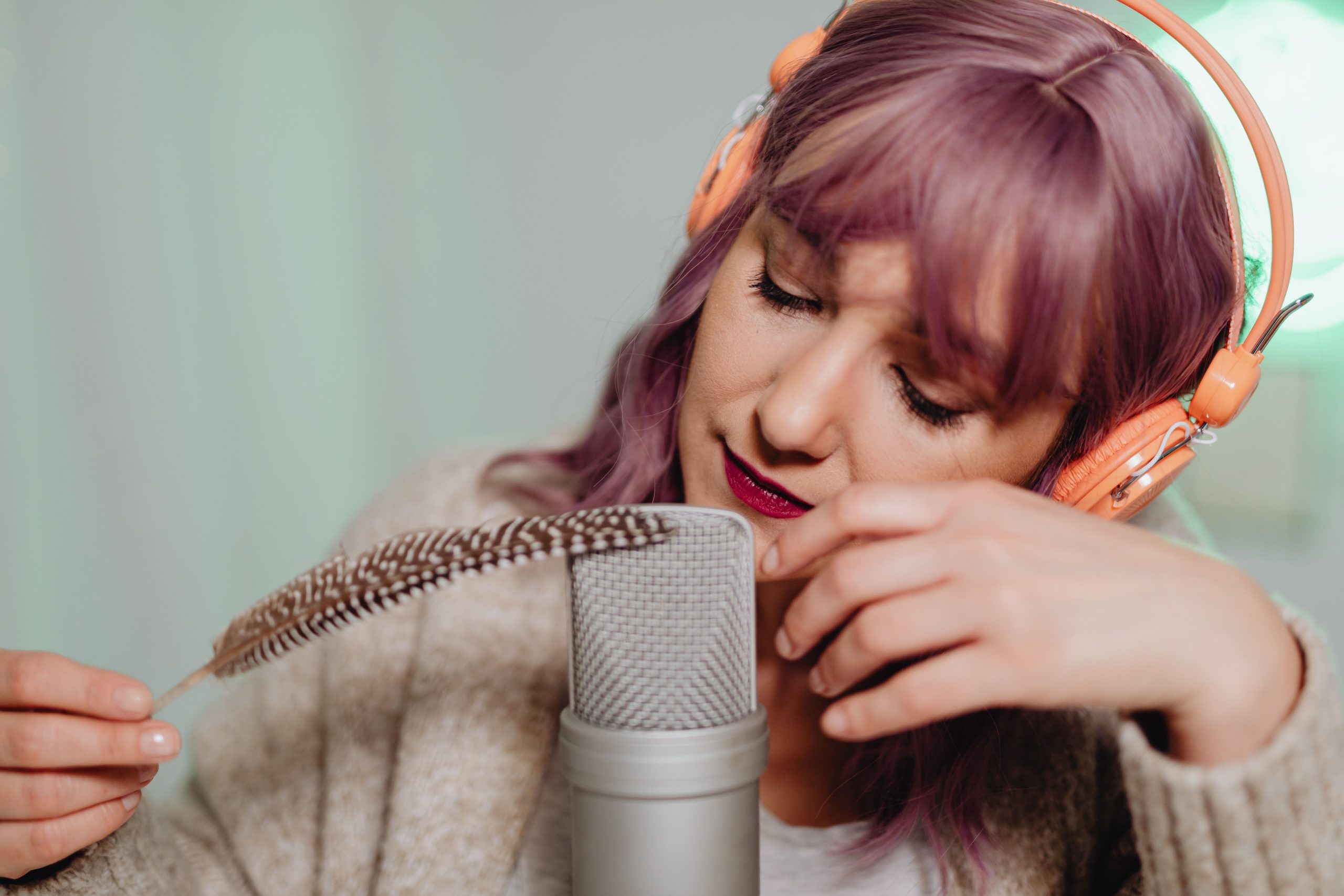 Femme enregistrant ASMR avec plume et microphone