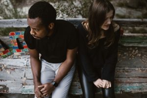 Couple assis séparé sur banc parc