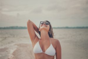 Femme souriante à la plage profitant du soleil