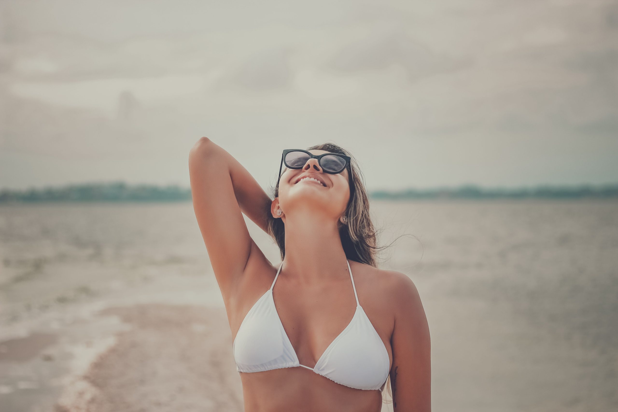 Femme souriante à la plage profitant du soleil