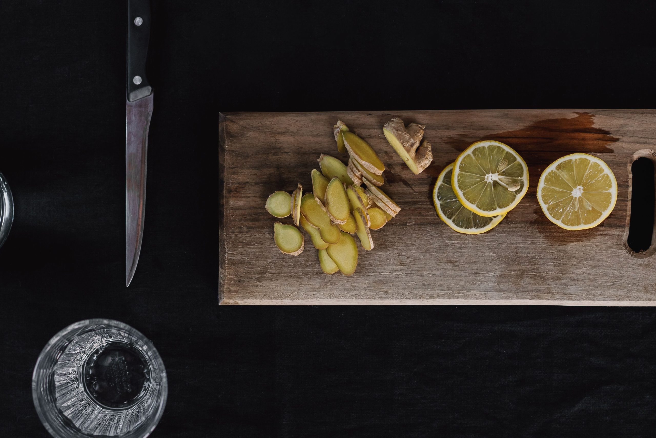 Gingembre tranché et citrons sur planche bois