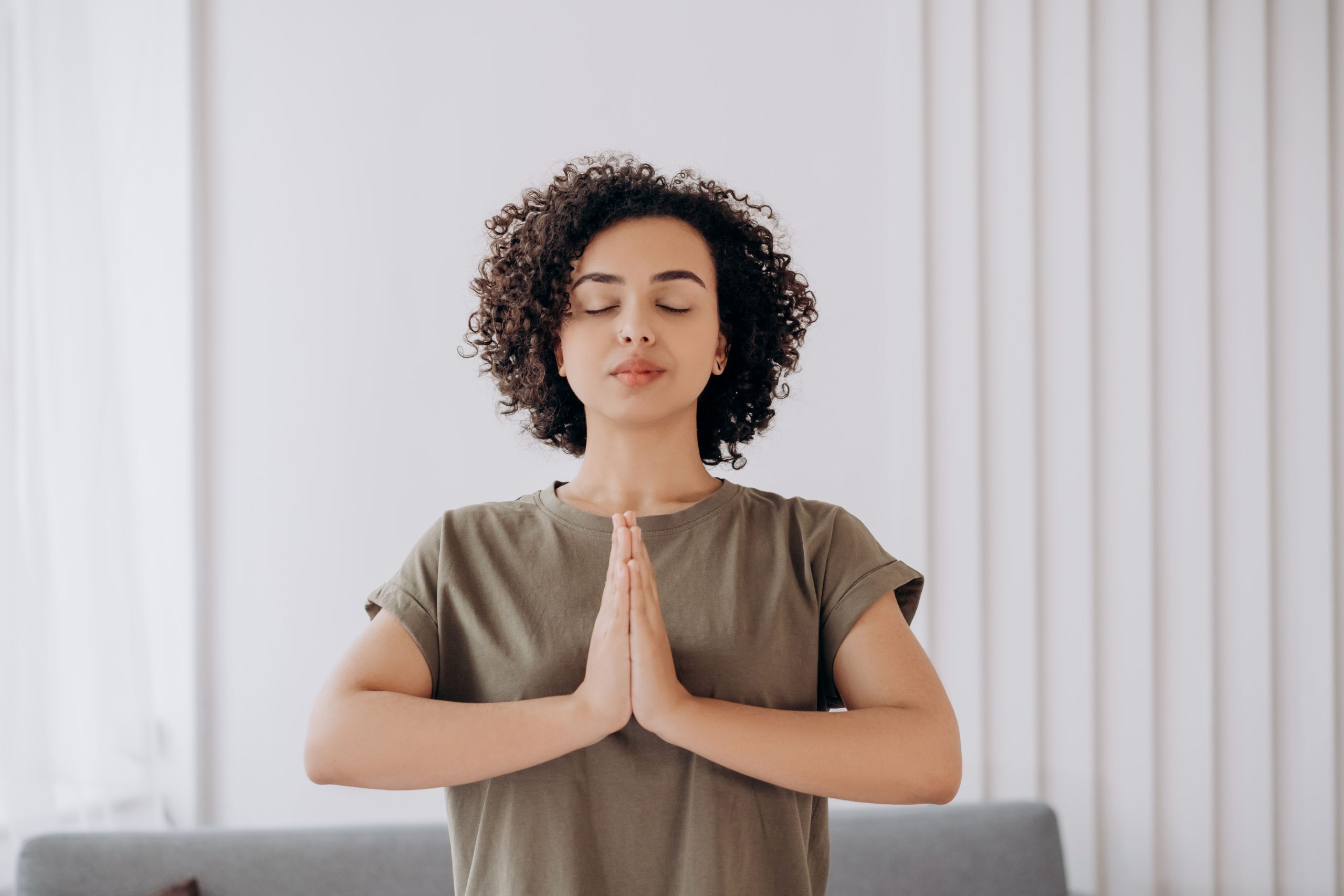 Jeune femme cheveux bouclés médite tranquille