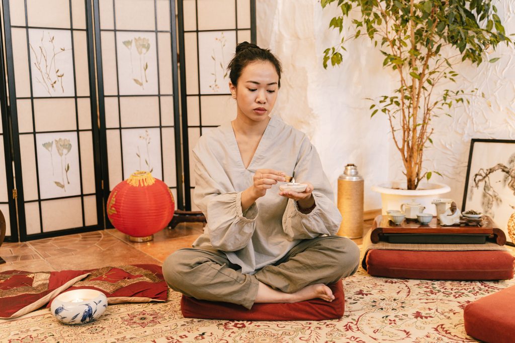 Femme asiatique méditant avec bougie dans cadre zen