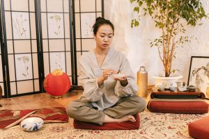 Femme asiatique méditant avec bougie dans cadre zen