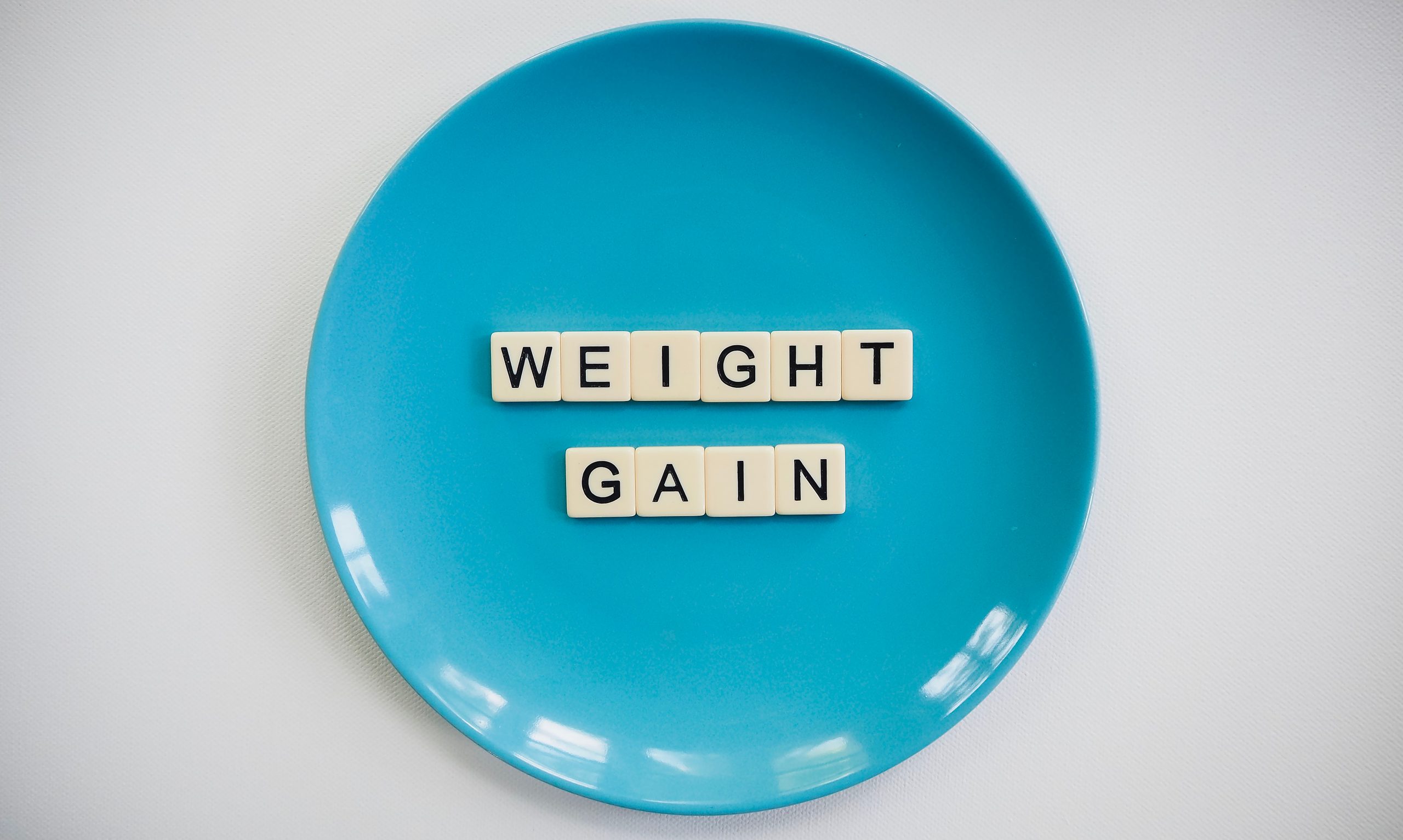Lettres Scrabble prise-de-poids sur assiette bleue
