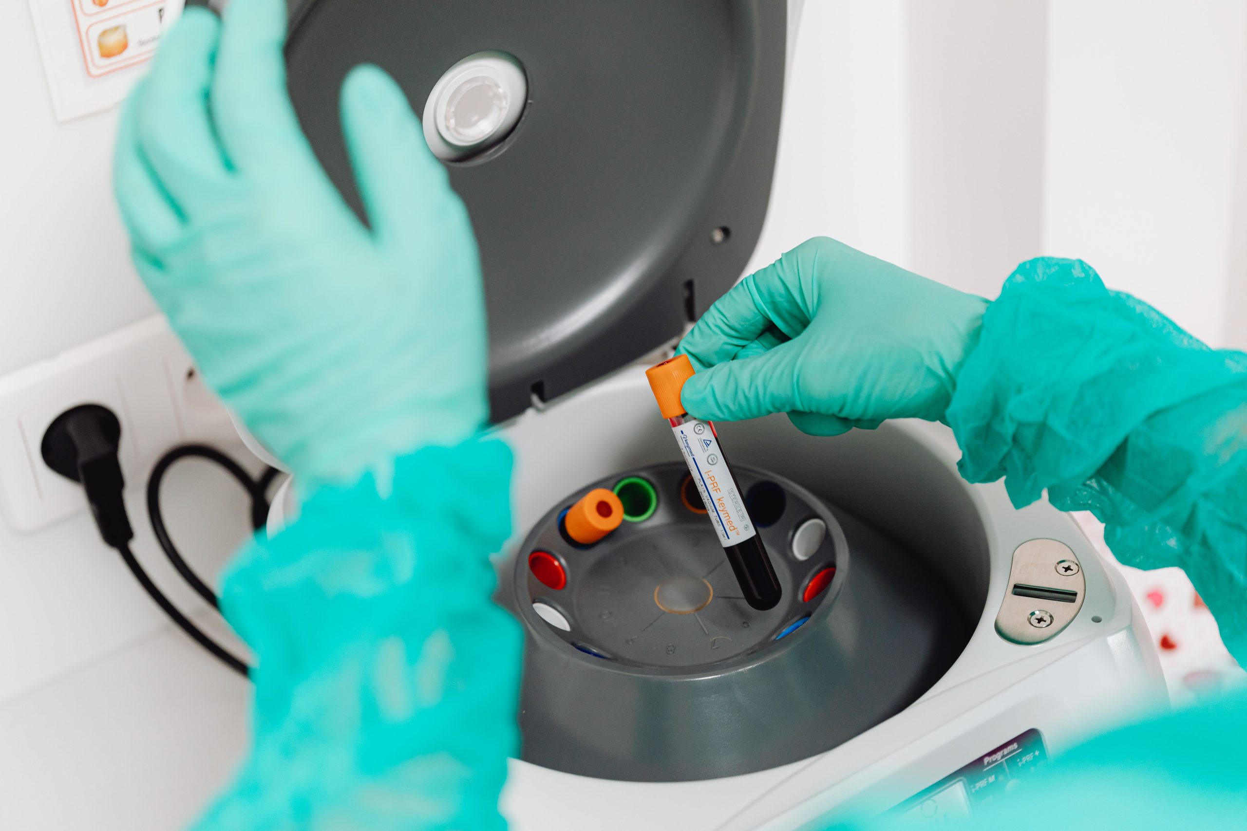 Technicien utilisant une centrifugeuse pour analyse sanguine