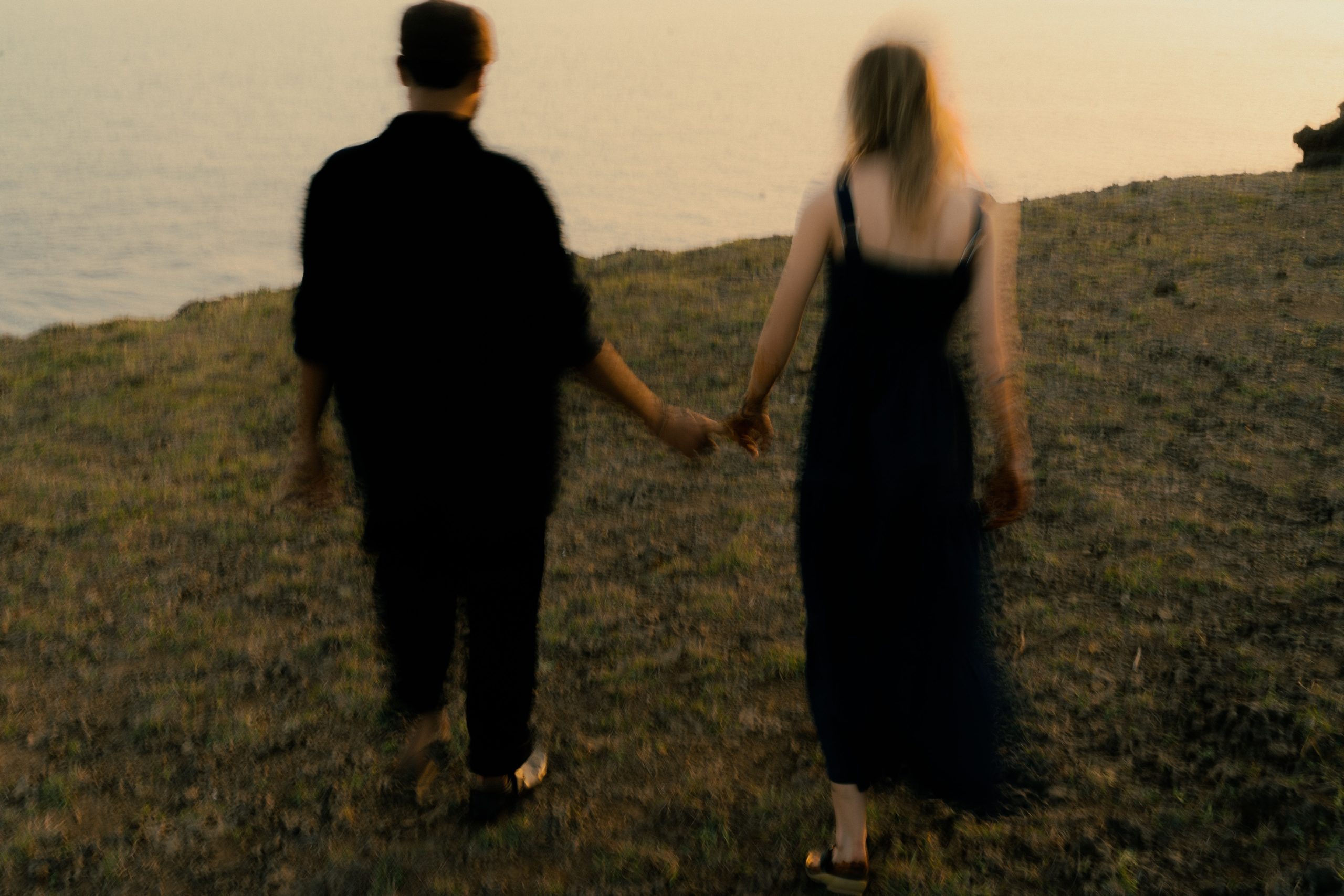 Couple marchant main dans la main au coucher soleil