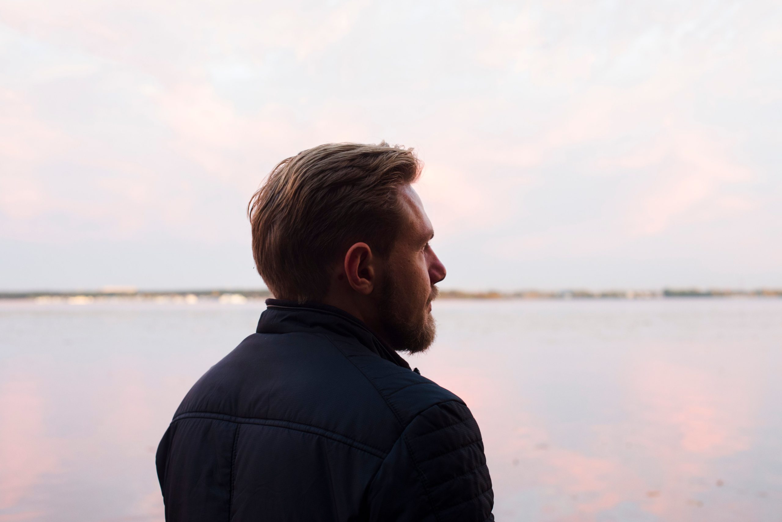 Profil d'un homme contemplant un lac au couchant