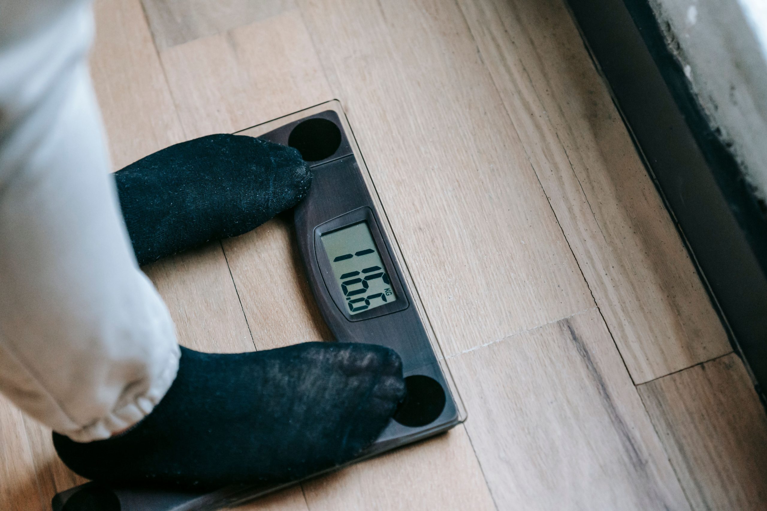 Personne en chaussettes pesant sur balance électronique