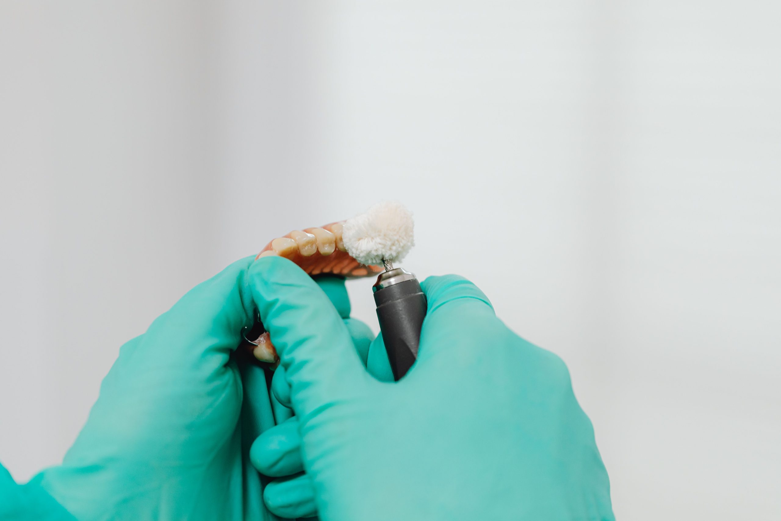 Professionnel polissant un dentier avec instrument
