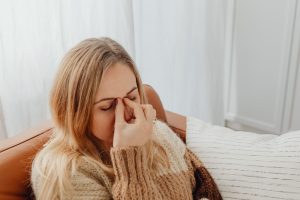 Femme souffrant de douleur sinusale en se tenant le nez